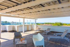 a patio with chairs and tables on a roof at Aparthotel Residences Ludovica & Valentina - Piscina Panoramica Vista Mare in Santa Maria al Bagno