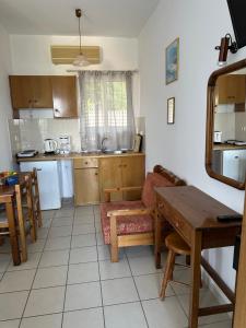a kitchen with a table and a couch and a table and chairs at Alexandra’s Studios Sunset View in Argostoli