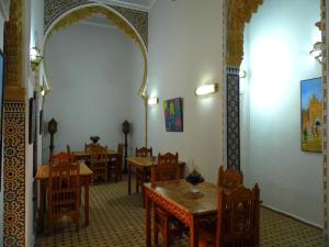 a dining room with wooden tables and chairs at Riad Marco Andaluz in Sale
