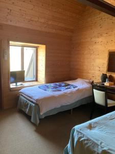 1 dormitorio con 2 camas y ventana en Oyado Raku en Takayama