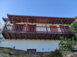 a building with a balcony on the side of it at Rita' s House Glossa Skopelos in Glossa