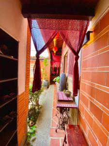 a small walkway in a house with red curtains at 彼岸古厝民宿-包棟優先--Biiann B&B in Jinning