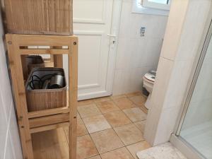 a small bathroom with a toilet and a wooden stand at Le Moulin Neuf in Beaupréau