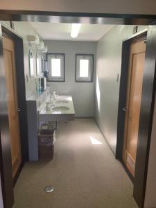 La salle de bains est pourvue d'un lavabo et d'un miroir. dans l'établissement Oyado Raku, à Takayama