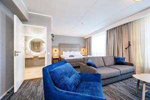 a living room with a couch and a blue chair at Dorpat Hotel in Tartu