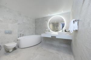 uma casa de banho com um lavatório, WC e um espelho. em Dorpat Hotel em Tartu