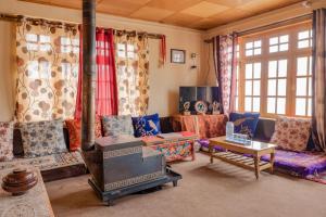 a living room with couches and a stove at MH - Pangong Homestay - B in Spangmik