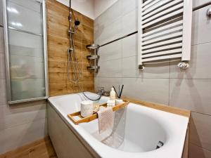 a bathroom with a tub and a shower and a sink at HARMONY Apartment - Zator Energylandia in Zator +5 photos