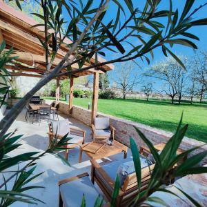 patio z krzesłami i drewnianą pergolą w obiekcie DOMAINE SAINT LOUP - 10min BEAUNE w mieście Saint-Loup-Géanges