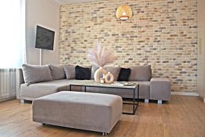 a living room with a couch and a brick wall at HARMONY Apartment - Zator Energylandia in Zator