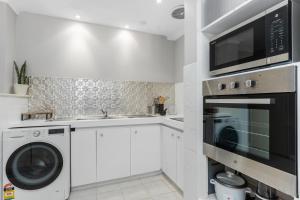 a kitchen with a washing machine and a microwave at Blackwood Stays in Spearwood