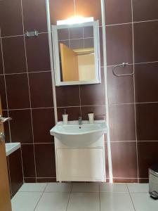 uma casa de banho com um lavatório e um espelho em VALENTINA LUXURY em PalaiónTsiflíkion