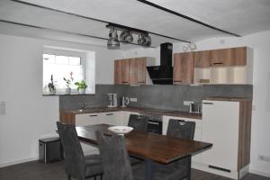 a kitchen with a wooden table and a dining room at Ferienwohnung-Naurath in Naurath
