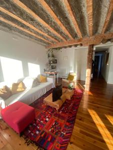 un soggiorno con divano bianco e tappeto rosso di La linterna de San Lorenzo a Burgos