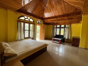 a bedroom with a large bed in a room with yellow walls at Hilltop Homestay in Itānagar