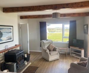 a living room with a chair and a television at Cruit Island Holiday Rent in Cruit
