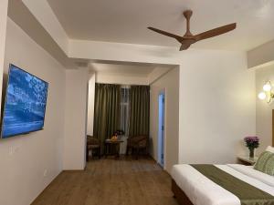 Hotel Pegasus Crown في شيلونغ: غرفة نوم بسرير ومروحة سقف