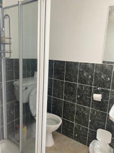 a bathroom with a toilet and a glass shower at Cruit Island Holiday Rent in Cruit