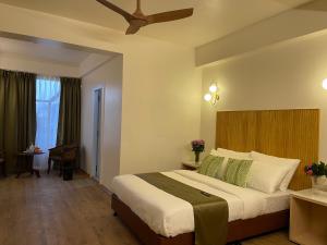 a bedroom with a large bed with a ceiling at Hotel Pegasus Crown in Shillong