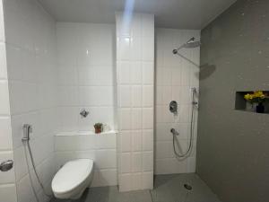 a white bathroom with a shower and a toilet at Hotel Pegasus Crown in Shillong