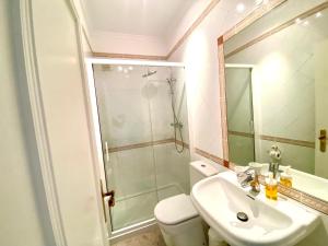 La salle de bains est pourvue de toilettes, d'un lavabo et d'une douche. dans l'établissement Vilamoura Central 2 Bedroom Apartment, à Vilamoura