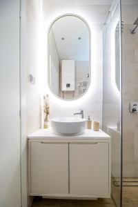 a white bathroom with a sink and a mirror at Enyana Luxury Suites in Kotor