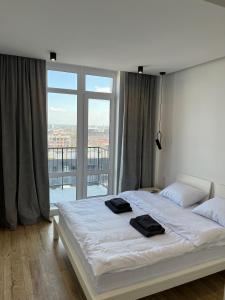 een slaapkamer met een groot bed en een groot raam bij VIP Apartmens Avalon in Lviv