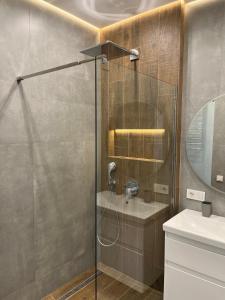 um chuveiro com uma porta de vidro na casa de banho em VIP Apartmens Avalon em Lviv