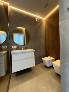 a bathroom with two sinks and a mirror at VIP Apartmens Avalon in Lviv
