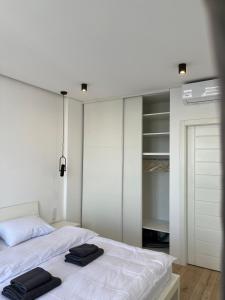 een slaapkamer met een wit bed en een kast bij VIP Apartmens Avalon in Lviv