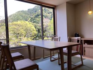 uma mesa e cadeiras num quarto com uma grande janela em Hotel Park em Gifu