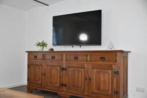 a flat screen tv on top of a wooden cabinet at Ferienwohnung-Naurath in Naurath