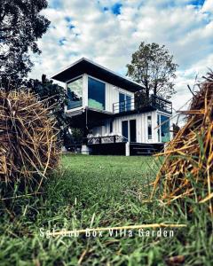 a house on a grassy field with a building at Sgt.Oub Box Villa Garden in Ban Som Phung Haeng (1)