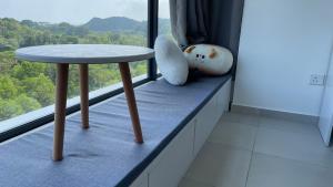 une table assise sur un rebord de fenêtre dans une pièce dans l'établissement Sandakan Homestay Apartment Forest Cabin 森林小屋 2R2B, à Sandakan