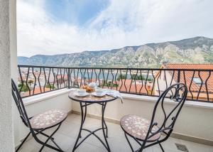 a table and chairs on a balcony with a view at Enyana Luxury Suites in Kotor