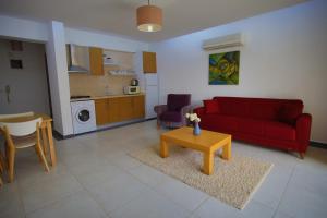 a living room with a red couch and a table at Odyssey Residence Apartments in Fethiye