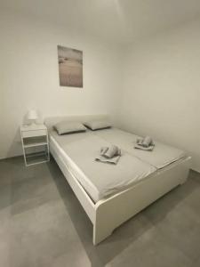 Dormitorio blanco con cama y mesa en Apartment Bella Vista Lugano, en Bissone