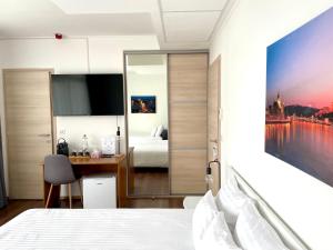 - une chambre avec un lit, un bureau et un miroir dans l'établissement Rooftop City Residence, à Budapest