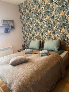 a bedroom with a large bed with a floral wall at Yellow apartman in Vrnjačka Banja