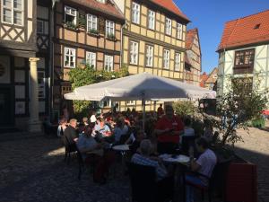 een groep mensen die aan tafels voor gebouwen zitten bij Remise 2 - a44208 in Wernigerode