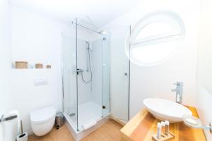 a white bathroom with a shower and a sink at Komfort-Hausboote am Naturhafen Krummin in Krummin +21 photos