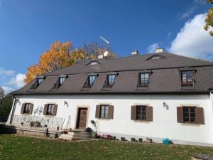 ein großes weißes Haus mit schwarzem Dach in der Unterkunft Sancta Katharina in Rozvadov