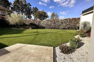 un jardín con un patio con césped sidx sidx sidx sidx en Magnifique Villa avec piscine, 