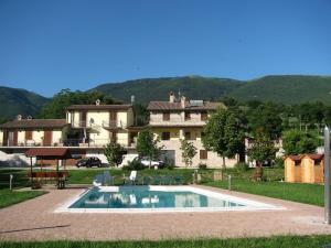 una piscina di fronte a una grande casa di La Sorgente Del Subasio ad Assisi