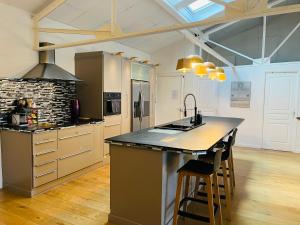 a kitchen with a large island in a room at Loft Évasion - Loft lumineux et climatisé entre Montpellier et les plages - 2 chambres - Parking - Tram in Lattes