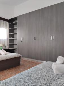 a bedroom with two beds and wooden cabinets at Michael Angelo Villa in Paphos City