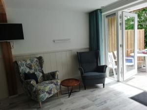カラントスウオーフにあるStrandhuisje DAAN dicht bij zee en strandのリビングルーム(椅子2脚、テレビ付)