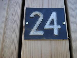 una placa azul con el número en un edificio en Strandhuisje DAAN dicht bij zee en strand, en Callantsoog