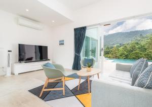 a living room with a couch and a tv at Vimaan Vilai - Secluded Pool Villa in Amphoe Koksamui