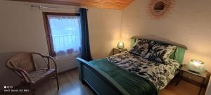 Un dormitorio con una cama y una silla y una ventana. en Gîte de la Batelière, en La Malène
